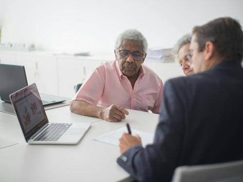 Three people looking at a computer